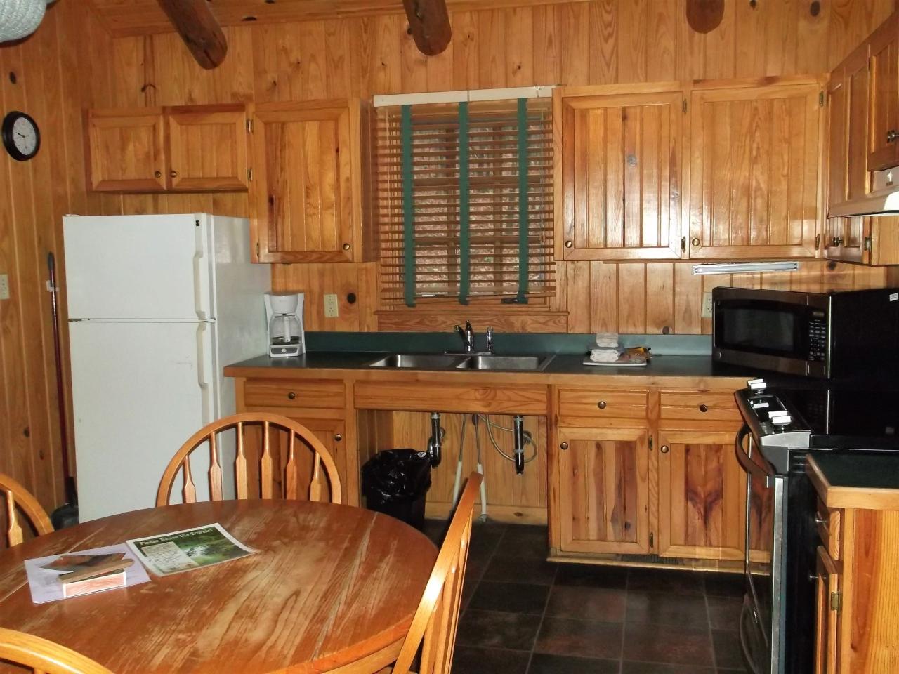 View of the kitchen with fridge, oven, microwave and dining area